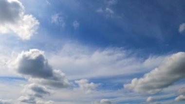 Bulutlar atmosferde dönüşür. Küçük beyaz bulutlar dramatik bir buluta dönüşür. Düşük açı. Zaman Uygulaması.