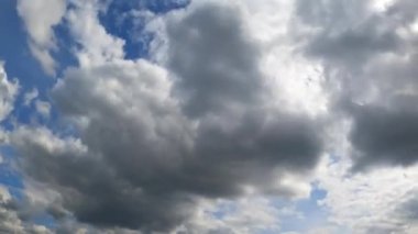 Mavi gökyüzü gri bulutlarla kaplı. Atmosferde yağmurlu bulut oluşumu. Düşük açı. Zaman Uygulaması.