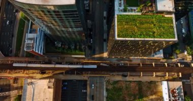 Tren caddelerin karşısındaki demiryolunun yanından geçiyor ve hareketli otoyollar. Şikago, Illinois, ABD 'nin kuş bakışı manzarası.
