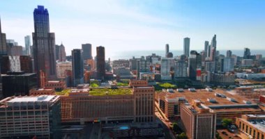 Tepesinde yeşil çimenler olan çok katlı binaya yaklaşıyoruz. Güneşli bir günde Chicago, Illinois, ABD Panoraması. Hava görünümü.