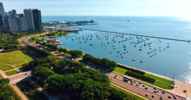 Chicago göl kıyısındaki körfez. Birden fazla yat suyun üzerinde duruyor. Michigan Gölü 'nün muhteşem bir su manzarası ve deniz kıyısındaki yeşil parkın bir kısmı..