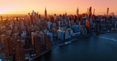 New York şehir merkezindeki binaların cephelerini kaplayan altın saat ışığı. Hava perspektifinden canlı şehir görüntüsü.