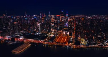 İnsansız hava aracı yükselirken devasa, aydınlık bir metropolün manzarasını gözler önüne seriyor. Gecenin en güzel manzarası New York, ABD Doğu Nehri 'nden.