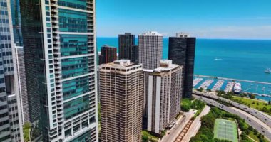 Michigan Gölü 'nün rıhtımındaki güzel modern bina cephesi boyunca uçuş. Yat iskelesi ve muhteşem gök mavisi su manzarası. Chicago, Illinois, ABD.