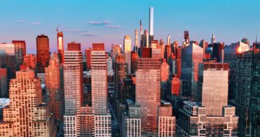 New York binalarının pencereleri batan güneşin turuncu ışığını yansıtır. Metropolis 'in mimarisi, yukarıdan bakıldığında.