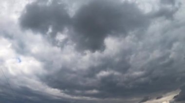 Gökyüzünü kaplayan gri dramatik bulut. Yağmur bulutları atmosferde toplanıyor. Düşük açı. Zaman Uygulaması.