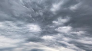 Yoğun dramatik bulut atmosferde yayılıyor. Gökyüzündeki yağmurlu bulutların alçak açılı görüntüsü. Zaman Uygulaması.