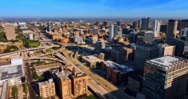 Chicago kavşağındaki karmaşık otoyol ve otobanlardan geçen bir nakliye aracı. Şehrin güneşli manzarası tepeden..