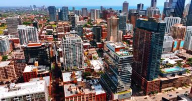 Chicago, Illinois, ABD 'nin renkli, parlak şehir manzarası. Uçsuz bucaksız güneşli şehrin üstündeki İHA görüntüleri. Michigan Gölü 'nün mavi su manzarası.