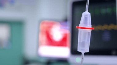 Serum deposuna damlayan tuzlu solüsyon. Kapatın. Ameliyat odasının bulanık arkaplanı.