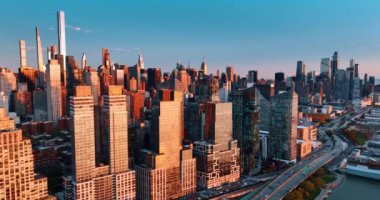 Doğu Nehri 'nin rıhtımında batan güneşin ışığında güzel binalar var. Gün batımına bakan gökdelenlere daha yakın uçuyorlar..