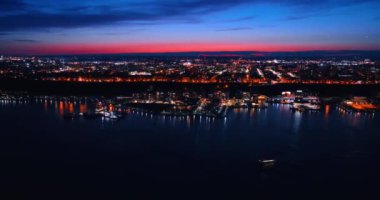 Doğu Nehri 'nin üzerinden uçarak Metropolis' in parlak rıhtımına yaklaşıyor. Pembe gökyüzünün altında. New York, Amerika Birleşik Devletleri 'nin gece manzarası.