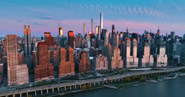 Doğu Nehri 'nin rıhtımındaki binalara daha yakın uçuyorlar. New York, ABD 'de günbatımı. Üst görünüm.