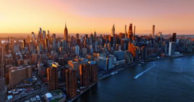 New York şehir merkezindeki binaların ön cephesinde turuncu ışık. Arka planda harika bir pembe gökyüzü. Hava görünümü.