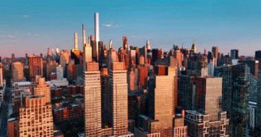 Muhteşem New York 'un güzel mimarisi, Amerika Birleşik Devletleri altın saatin turuncu ışığıyla aydınlandı. Hava aracı günbatımında binaların tepesine yaklaşıyor..