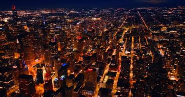 Geceleri büyük bir metropolün aydınlık caddeleri ve binaları. Chicago, Illinois, Birleşik Devletler İHA görüntülerinden.