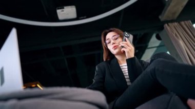 Gözlüklü genç bir kadın dizüstü bilgisayara şaşkınlıkla bakıyor. Akıllı telefonlu esmerin düşük açılı görüntüsü şok edici bir haber veriyor..