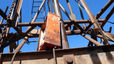 Altında durup bir sondaj alanının yüksek kulesine bakmak. Kaynak üretimi için kullanılan ekipman.