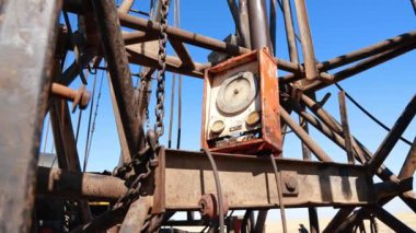 Sondaj alanındaki borular, zincirler ve kontrol masası. Doğal kaynaklar üretimi için ekipman. Düşük açı görünümü.