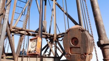 Petrol üretimi için makineler, mekanizmalar ve cihazlar. Sondaj alanındaki kulenin düşük açılı görüntüsü.