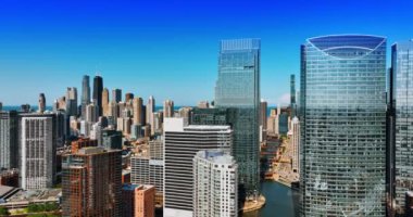 Mavi açık gökyüzü yüksek binaların ayna camlarına yansıyor. Chicago, Illinois 'in modern şehir merkezindeki ofis merkezlerine yaklaşıyoruz..