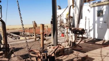 Petrol veya gaz sondajı için sondaj kulesindeki görüntüler. Metal kaynakların üretimi için inşaat sahasındaki metal desteğine bağlı ekipman.