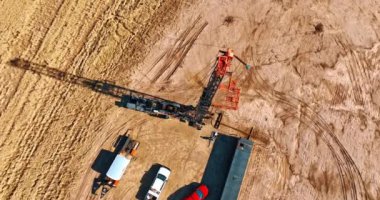 Sondaj alanındaki petrol kuyusuna iniyoruz. Az sayıda kamyon ve petrol veya gaz üretimi için kule bulunduğu yerin üst görüntüsü.