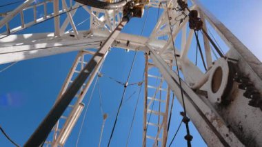 Ortasında dönen direği olan petrol platformu. Kulede doğal kaynakları delen alçak açılı bir görüntü..