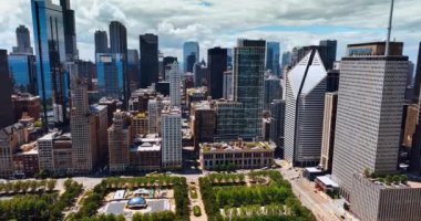 Şikago, Illinois, ABD 'deki Millennium Park' ın üzerindeki güzel binaya yaklaşıyoruz. Gündüz vakti Bulut Kapısı anıtının üzerinde uçmak.
