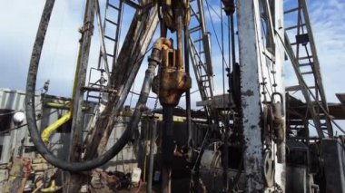 Petrol üretimi için doğal kaynakları sondajlıyoruz. Teçhizatlı yüksek metal derrick. Düşük açı görünümü.