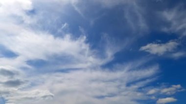 Hafif yumuşak bulutlar gökyüzünde süzülür. Bulutlar atmosferde toplanıyor. Düşük açı. Zaman Uygulaması.