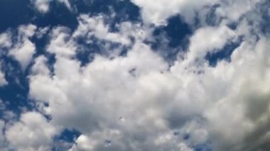 Bulut kümeleri atmosferde iki yönde hareket eder. Bulutları değiştiren koyu mavi bir gökyüzü. Düşük açı. Zaman Uygulaması.
