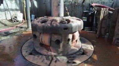 Petrol üretimi sahasında dönüşümlü olarak sıkıcı. Kapatın. Büyük bir petrol kuyusunun dibinde duruyor..