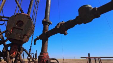 Sıkıcı petrol üretim sahasında metal paslı ekipmanlar. Çölde sondaj işlemi için yüksek kuyu. Düşük açı görünümü.