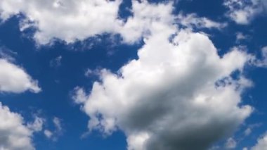 Yumuşak beyaz bulutlar rüzgarda uçar. Yumuşak kümülüs bulutları gök yüzünde hızla hareket eder. Düşük açı. Zaman Uygulaması.