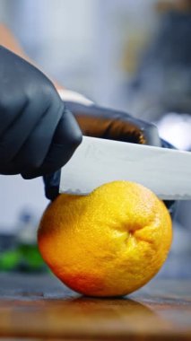 Siyah lateks eldiven giyen eller greyfurdun kabuğunu soyar. Kapatın. Arkaplan bulanık. Dikey video.