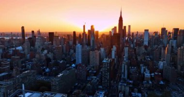 Muhteşem New York 'un siluetinin ardında parlak batan güneş. Gün batımında sayısız araba canlı şehrin sokaklarında hareket ediyor. Üst görünüm.