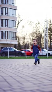 Sevimli mutlu bebek kameraya doğru koşuyor. Sabun köpüğü yakalayan tatlı çocuk. Dikey video.