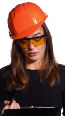 Kadın inşaat mühendisi. Kadın müteahhit portreyi koruyucu kaskla izole etti. Dikey video