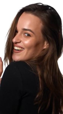 Kadın manken pozu. İzole edilmiş beyaz arka planda gülümseyen dost canlısı bir kadın portresi. Dikey video