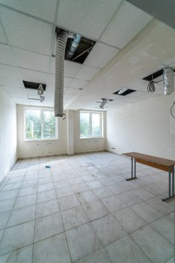 Açık tavanlı, parlak, havadar ofis alanı. Açık tavanları ve doğal ışıkla dolu geniş pencereleri olan boş bir ofis.