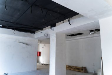 Ham inşaat aşamasında ticari alanı yeniledim. Ticari bir alanın içinde bitmemiş duvarlar ve açıkta kalmış kablolar sergileniyor.