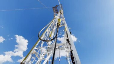 Döner ekipmanlı yüksek metal derrick. Doğal kaynaklar için sondaj alanı. Düşük açı görünümü.