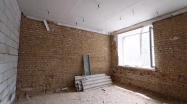 Binada inşaat halindeki iki pencereli boş tuğla duvar odası. Odadan çıkıp karanlık salona gitmek..