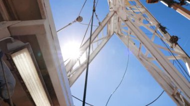 Boer, petrol veya gaz çıkarmak için toprağı kazıyor. Doğal kaynaklar üreten ekipmanlara düşük açılı bakış açısı.