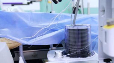 Ameliyat odasındaki ameliyat masasının yanında akciğer vantilatörü pompası. İşlem sırasında çalışma ekipmanları.