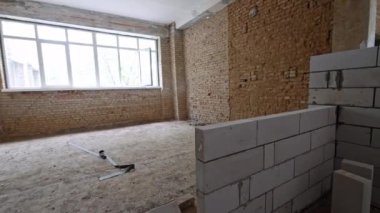 Beyaz tuğla duvar eski evin odasına inşa edilmiştir. Binanın içi yenileniyor..