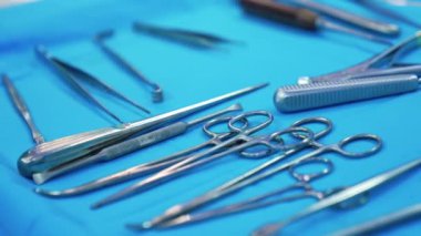 Cerrahi standında çeşitli tıbbi aletler var. Ameliyat için çeşitli metal aletler hazırlandı. Kapat..