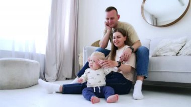 Anne, baba ve küçük oğulları oturma odasındalar. Evde birlikte sevgi dolu bir aile..