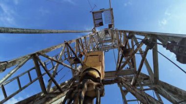 Sıkıcı petrol için metal bir hendeğin dibindeki görüntüler. Sıkıcı ekipmanlar çalışırken kalın teller titreşir. Düşük açı görünümü.